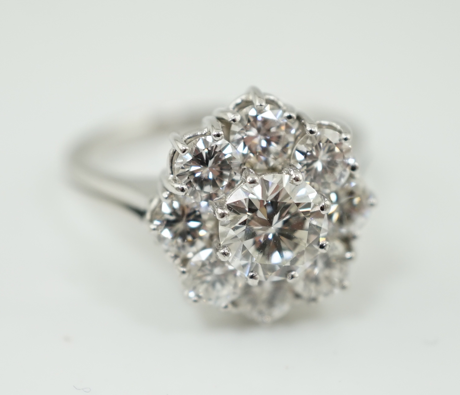 A modern 18ct white gold and round brilliant cut nine stone diamond set cluster ring